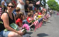 People sitting along road waiting for Memorial Day Parade